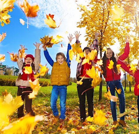 A group of children playing in the leaves.