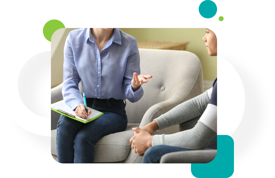 A woman sitting on the couch talking to another person.