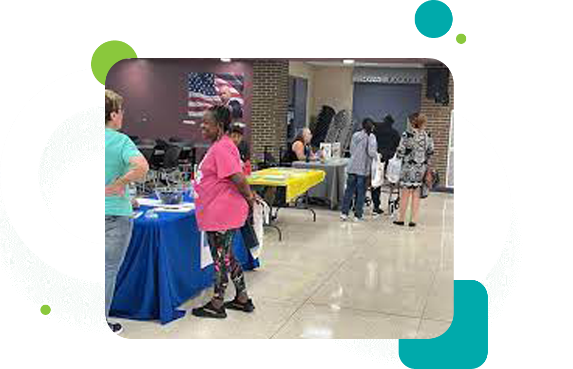 A group of people standing around tables in an event.