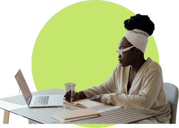 A woman sitting at a table with a laptop and cup.